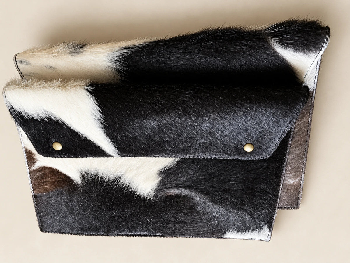 Angled view of ADEEM cowhide sleeve showing the folded flap and stitched edges