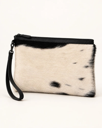 Rear view of the ADEEM black and ivory cowhide clutch; natural markings vary between pieces; AI-assisted product image.